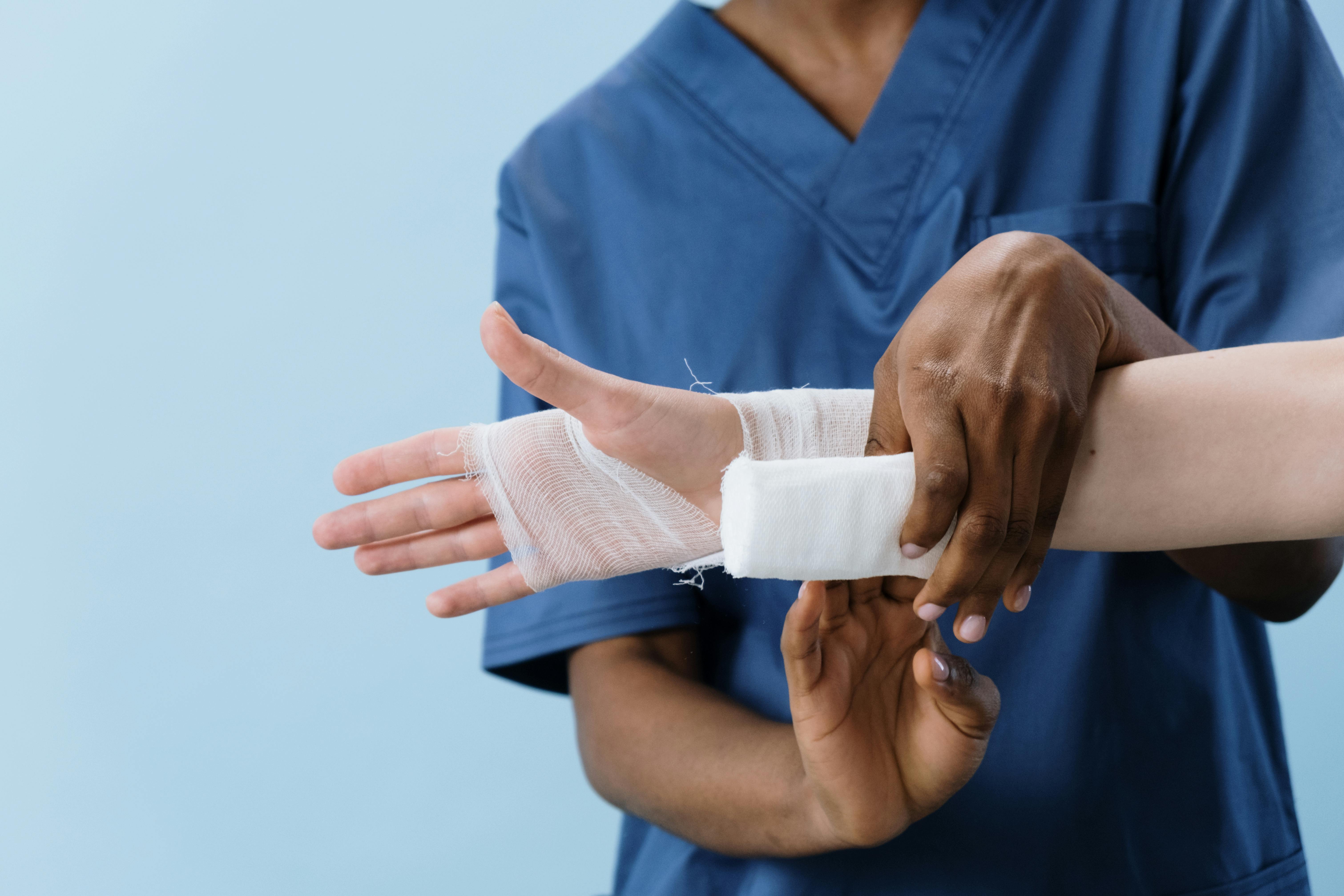 Medical professional bandaging a patient's hand for personal injury claims